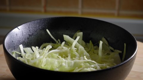 Close-up View of Sliced Cabbage Bowl, Cooking Scrambled Eggs - Tilt Shot