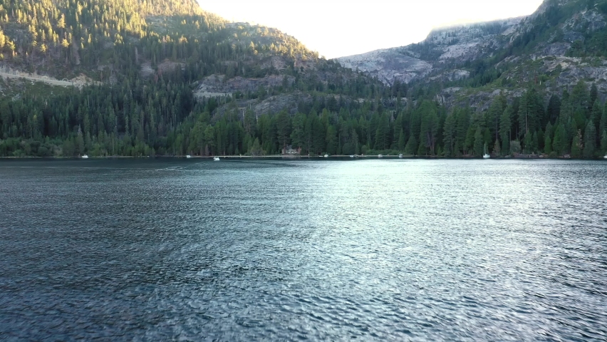 Forest Mountains On Serene South Lake Tahoe With Tourists Boating During Summer In California, United States. Aerial Pullback Shot
