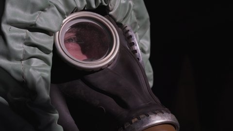 Face of very tired man breathing hard through gas mask close side view