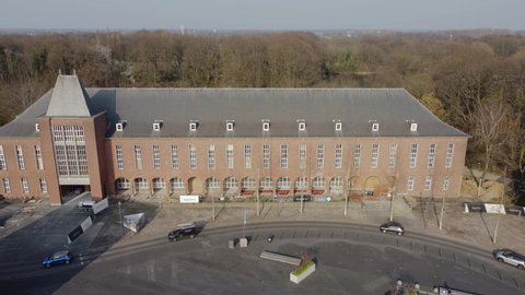 Mortsel, Antwerp, Belgium 25 March 2022 : Mortsel city hall and town square seen from above with traffic driving on road. Ukrainian flag hanging on building. Drone aerial view from above