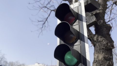 Close-up traffic light, traffic flowing in the city. Red light, yellow light, green light. Stop, get ready, move