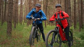Senior couple bikers outdoors in forest in autumn day. - Powered by Shutterstock - Get 15% off with code: PIKWIZARD15