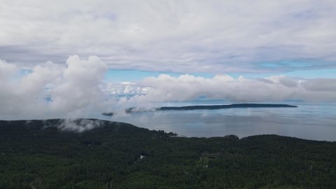 Thick cloud hovering over the Powell River along the stunning Sunshine Coast Trail in British Columbia, Canada. Wide angle aerial shot