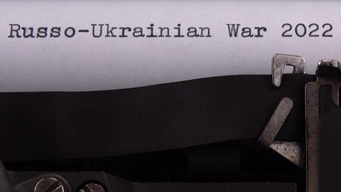 Typing phrase "Russo-Ukrainian War 2022" on retro typewriter.