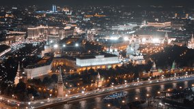 Close up view from above to Moscow Kremlin at night, beautifully illuminated with evening lights and surrounded by streets with busy traffic, all in motion timelapse.