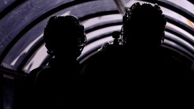 Silhouettes of hockey players with helmets waiting for game start in tunnel near ice rink closeup backside view - Powered by Shutterstock - Get 15% off with code: PIKWIZARD15