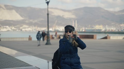 Novorossiysk, Russia, February 2022. Girl street musician plays the flute on the city street.