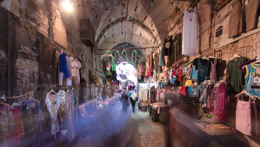 The colorful souk with clothes in the old city of Jerusalem Israel timelapse hyperlapse. Crowd of people passing by on this makret