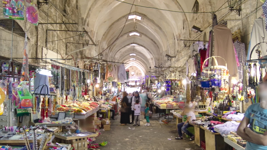 Walking inside the colorful souk in the old city of Jerusalem Israel timelapse hyperlapse. Crowd of people passing by on this makret