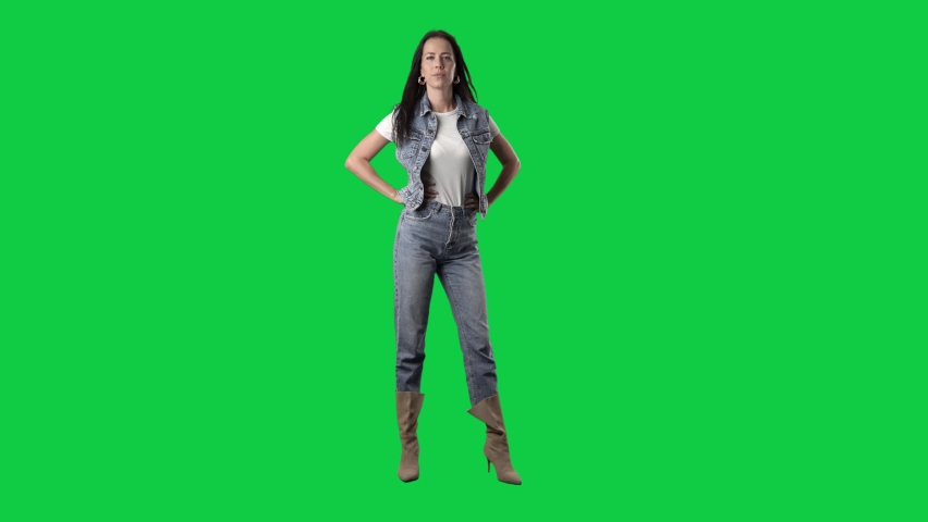 Slow motion of stylish cowgirl jeans and boots girls posing at camera. Full body isolated on green screen background
