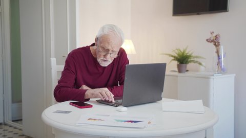 Grandpa in glasses looking for information on the Internet
