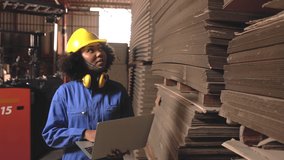 Engineer  african woman wearing safety helmet and vest holding clipboard and take note on the paper in the automotive part warehouse.Factory for the manufacture and processing of paper. - Powered by Shutterstock - Get 15% off with code: PIKWIZARD15