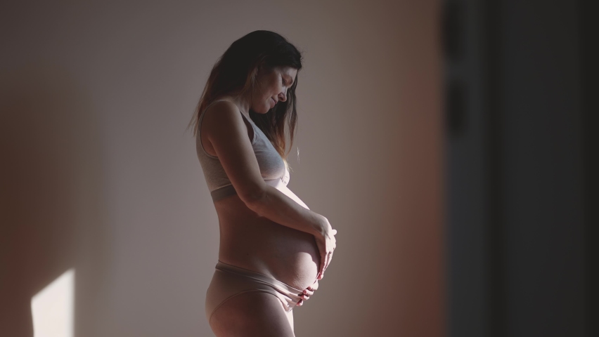 pregnant woman. health pregnancy motherhood procreation concept. close-up belly of a pregnant woman. woman waiting for a newborn baby. pregnant woman holding her sun belly indoors Royalty-Free Stock Footage #1089091921