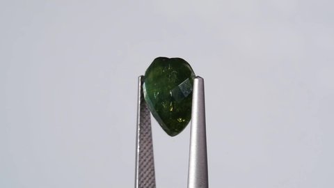 natural blue oval sapphire gemstone in the tweezers