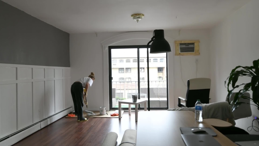 Renovation work in residential premises. People are painting the interior wall in apartment. Time lapse