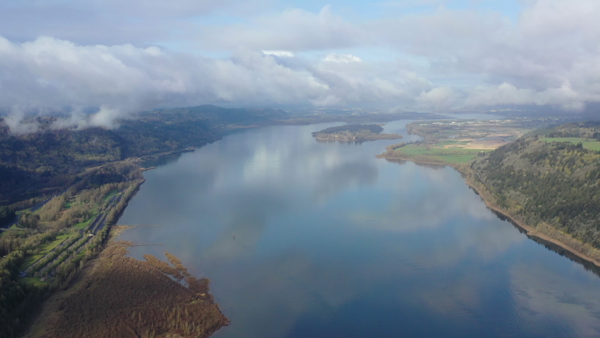 Low clouds drift over the Columbia River which runs between Oregon and Washington. The scenic Columbia River Gorge, with the Columbia River flowing through it, is over 80 miles long.