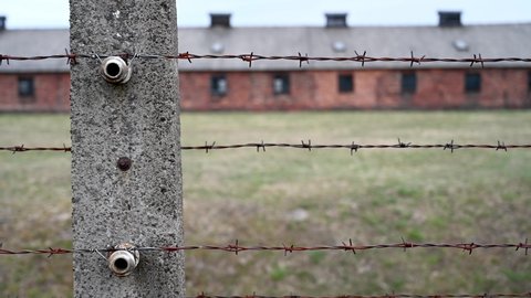 Auschwitz, Poland, March 2022: Barbered wire in Auschwitz concentration and extermination camp. Barracks in concentration camp. Nazi death camp.  