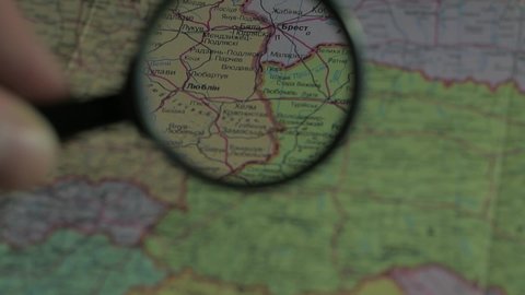 War in Ukraine. Look at map with magnifying glass close up near western border of Ukraine: Brest, Lublin, Lviv, Uzhgorod. Ukrainian language paper map
