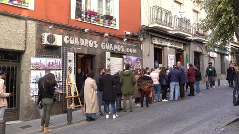 Madrid, Spain- March 2022: El Capricho Extremeno, a popular take-away to-go food diner cafe restaurant with a long queue of customers patrons waiting in line to get served. Travel in winter Europe. 