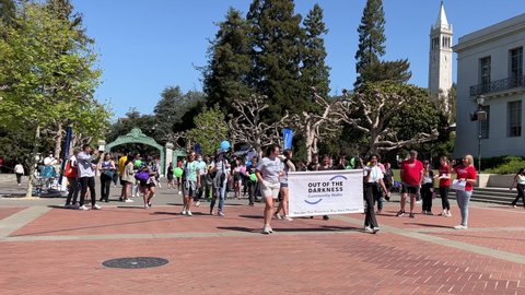 Berkeley, CA - April 9, 2022: 4K HD video of unidentified participants of an Out of the Darkness rally marching from Sproul Plaza on UC Berkeley campus.