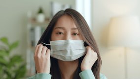 Young Asian woman takes off protective mask and look at camera after coronavirus pandemic end with smile - Powered by Shutterstock - Get 15% off with code: PIKWIZARD15