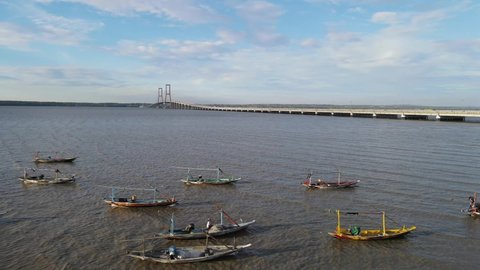 
Panorama of the Suramadu bridge with a small boat on the Surabaya beach in the afternoon