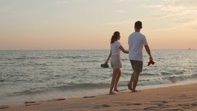 Vacation loving couple walking on beach together at sunset landscape, relaxing vacation travel summer, Asian man and woman in love holding hands walks along the sandy seashore - Powered by Shutterstock - Get 15% off with code: PIKWIZARD15