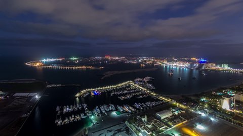 Jumeirah Palm Island night to day transition aerial timelapse dubai shot from the rooftop of the tower in dubai marina, uae. Beautiful cloudy sky