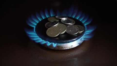 Russian ruble coins on the gas stove burner. Russian ruble on burning gas. The concept of the price for Russian gas in Europe. Payment for gas in Russian rubles