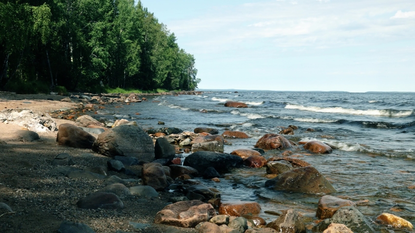 Landscape of Lake Onega on a sunny summer day. Beautiful rocky shore and water.
Amazing waves 
splashes  crashing on the rocks coast.  | Shutterstock HD Video #1089113745