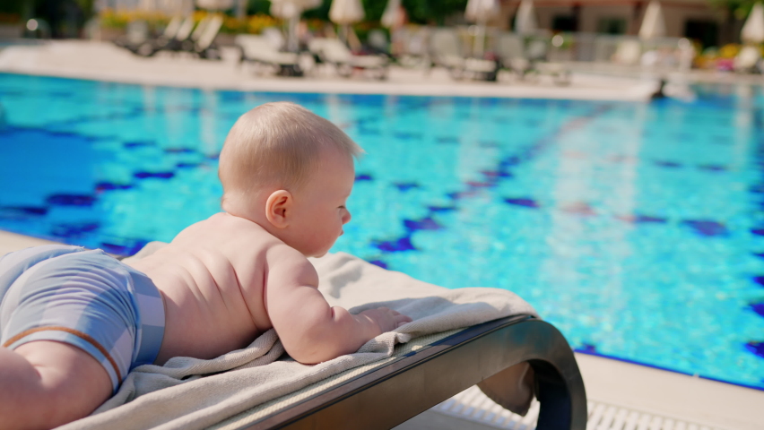 Cute baby having family rest on beach spa resort. Toddler lie near water in summer. little fun kid on vacation relax at swim pool, summertime child person, concept of childhood, happiness and holiday