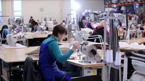 Large sewing workshop. seamstresses make clothes in a factory. Garment factory. Clothes production workshop