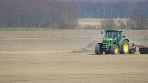 Tallinn Estonia 2021 April 02: Flattening out the soil of the field in Tallinn Estonia using the roller tractors for agriculture