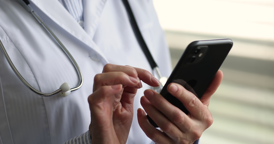 Smart medicare. Close up mobile phone device in female doctor hands. Modern day physician contact patient remotely in web chat give urgent recommendation write treatment prescription online using cell | Shutterstock HD Video #1089117139
