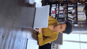 Vertical view focused young African woman study from home use laptop write down information from online source search answer to question on website. Serious teen female do exercise pass elearning test - Powered by Shutterstock - Get 15% off with code: PIKWIZARD15