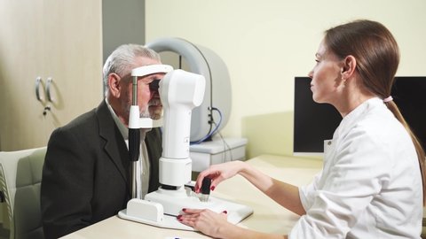 ophthalmologist examination of the elderly man on the corneal topographer. Videokeratograph is medical device for determining curvature of cornea. mandatory device for modern clinic or opticians shop.