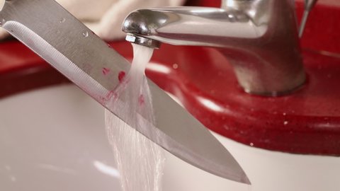 Washing bloody knife in sink.
