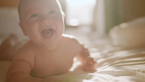 Beautiful Smiling Baby, gorgeous little baby lie on bed and smile at camera with nice soft focus background. Little girl or boy is humming, real original audio track, lovely asian baby playing at home - Powered by Shutterstock - Get 15% off with code: PIKWIZARD15