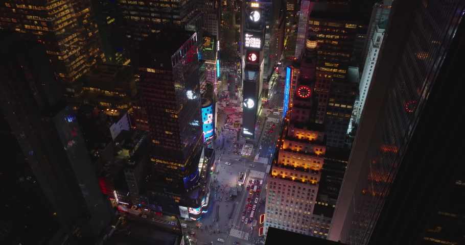 High angle footage of Times Square at night. People enjoying atmosphere. Large digital displays showing advertisements. Manhattan, New York City, USA in 2021