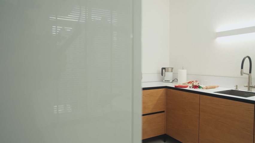 Young woman opens the oven door to check the ginger cookies. Focused woman takes a tray of cookies out of the oven