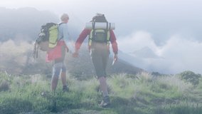 Composite video of clouds against caucasian couple hiking on the mountains. national walking day awareness concept