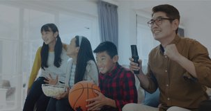 Composite video of confetti falling against asian family cheering while watching sports on tv. sports and entertainment concept