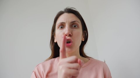Censorship concept, Secret information. scared and worried female looking at camera and putting finger on lips. isolated on a white background
