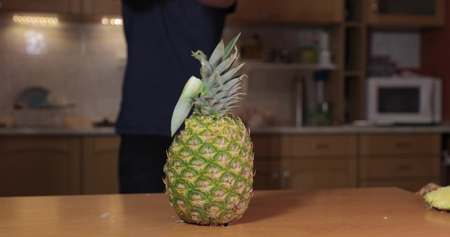 Slicing up a pineapple with an axe strike, chopping in half