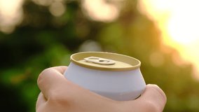 Close-up of hands opening cans of cold beer with bokeh nature background. - Powered by Shutterstock - Get 15% off with code: PIKWIZARD15