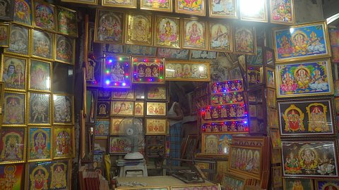 Chennai, Tamil Nadu, India, April 2020 - Shopkeeper selling photo frames of god and goddess - Roadside, marketplace, Indian culture. Pictures of Indian deities in the local shops - Local bazaar, wo...