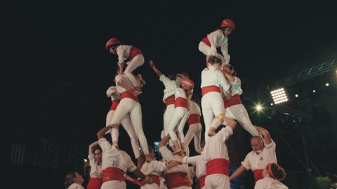 Barcelona, Spain; September 24th, 2021: Barcelona Castellers. Building of a human tower performance during La Merce Festival. Catalan tradition of colla castellera. Red belts and helmets.