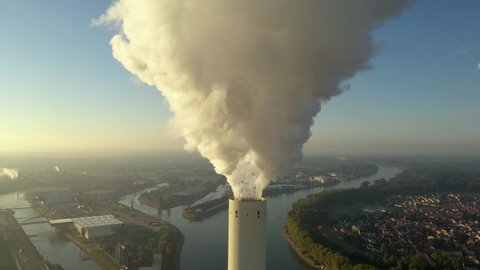 Dramatic smoke from a chimney, an industrial plant in city aerial view. Air pollution and global warming from a coal-fired power station.  and global warming. Close up and medium close shot.