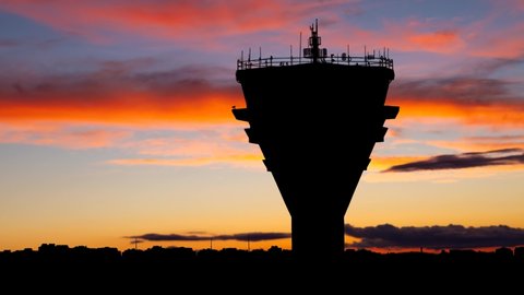 Modern Air Traffic Control Tower at Twilight, Time Lapse with Colourful Sky and Dark Skyline of Airport