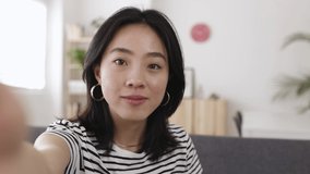 POV happy young asian woman having a video call through mobile phone network app at home. Cheerful chinese female talking on videoconference by cellphone - High quality 4k footage